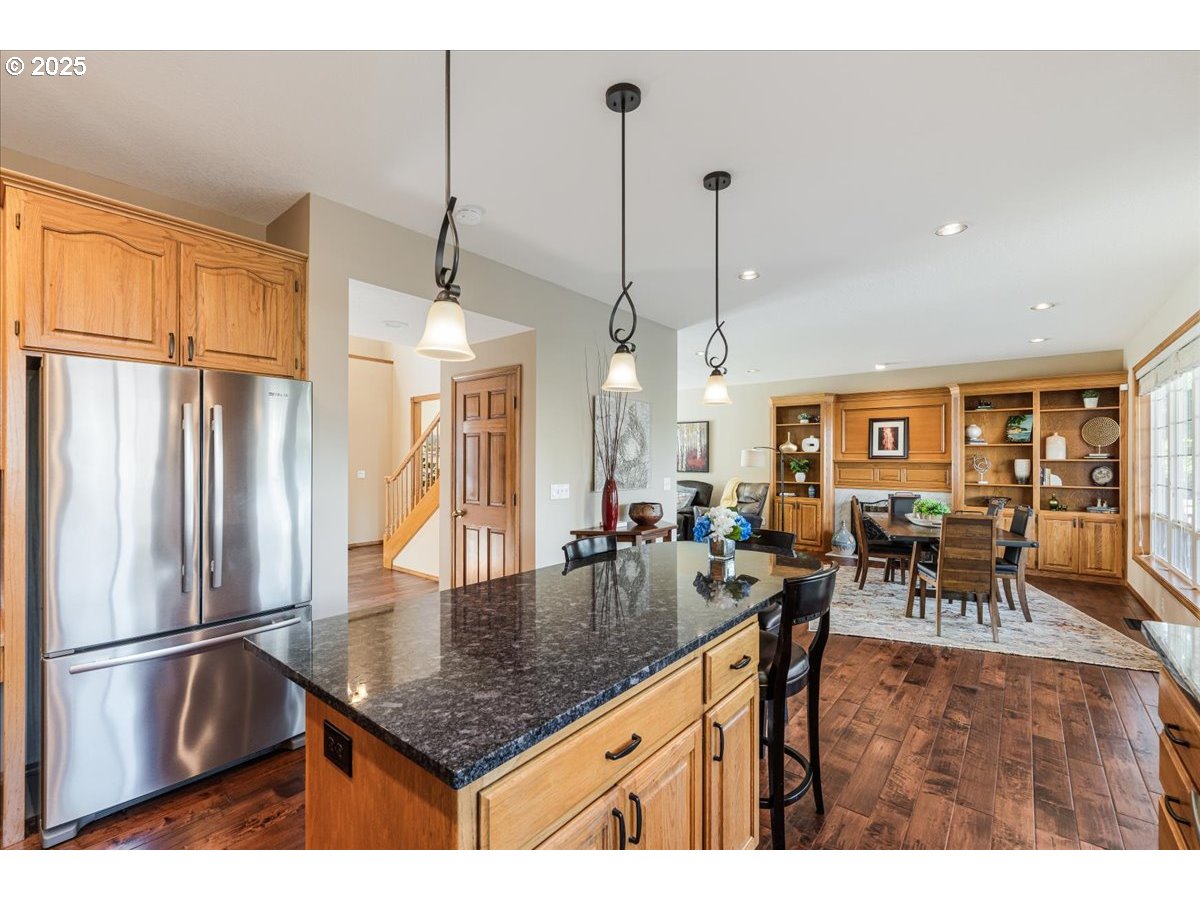 16706 Northwest Waterford Way Portland, OR 97229 - Photo 19 of 45 a kitchen with stainless steel appliances granite countertop a table chairs and a refrigerator