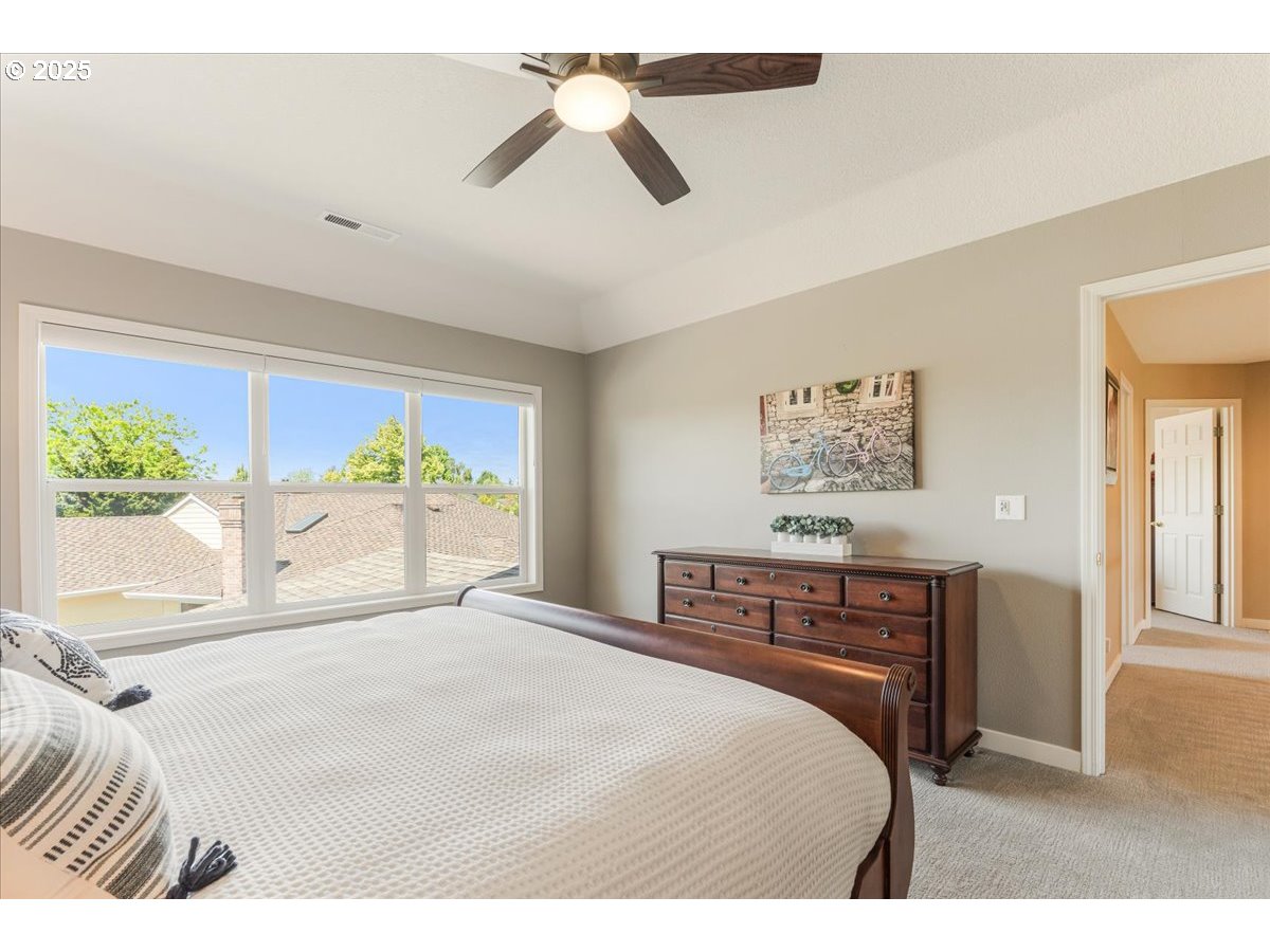 16706 Northwest Waterford Way Portland, OR 97229 - Photo 25 of 45 a bedroom with a large bed and a large window