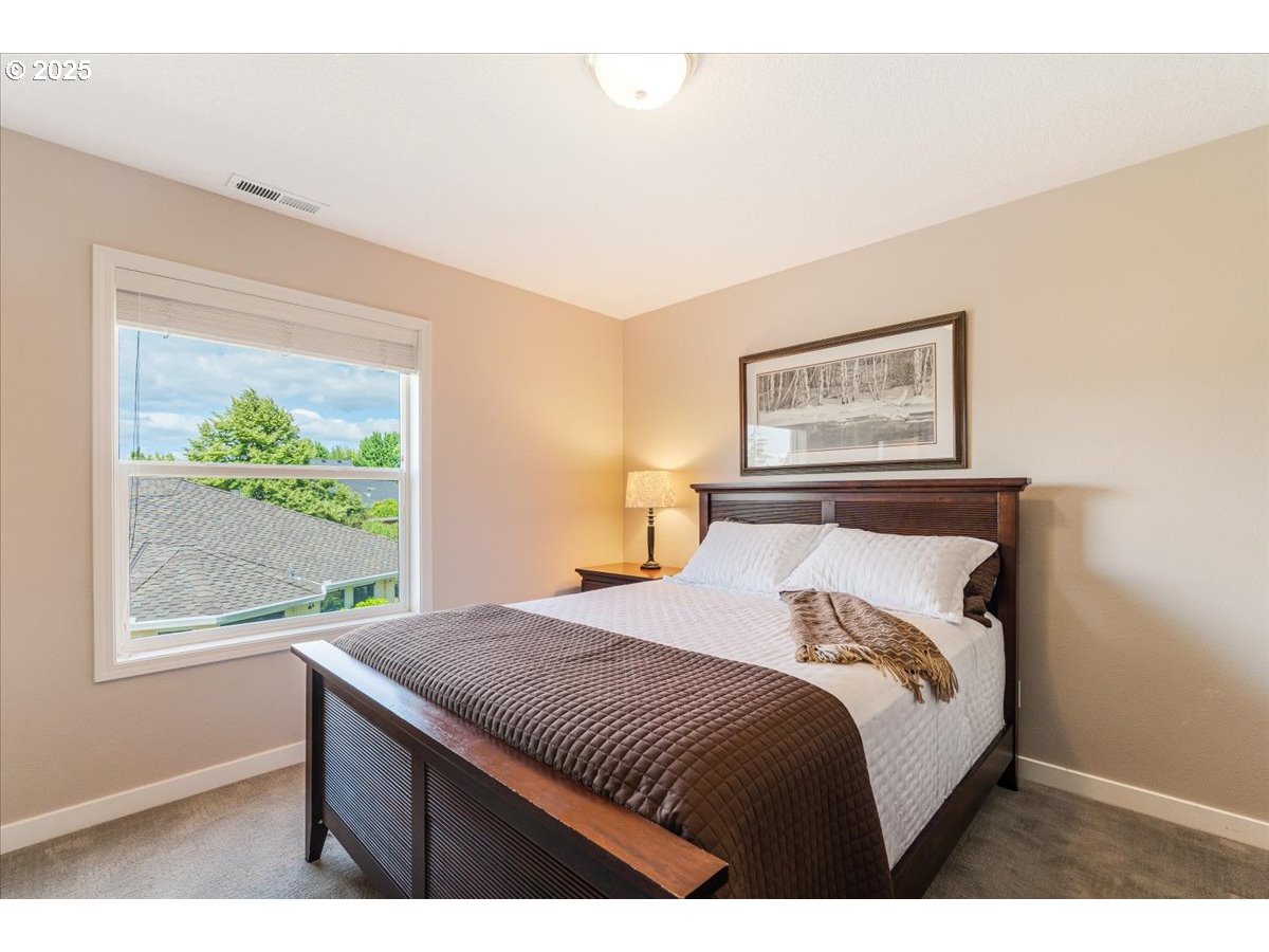 16706 Northwest Waterford Way Portland, OR 97229 - Photo 32 of 45 a bedroom with a bed and a painting on the wall