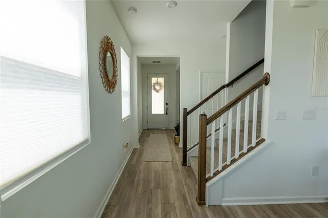 a view of a hallway with wooden floor and staircase