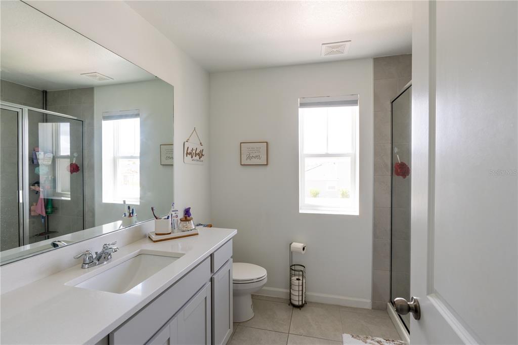2069 Valencia Blossom Street Clermont, FL 34711 - Photo 17 of 24 a bathroom with a toilet sink and mirror