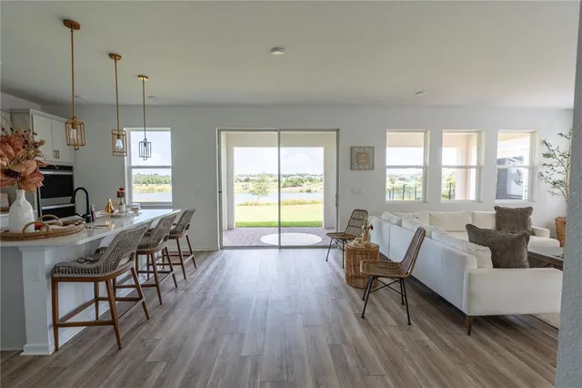 a living room with furniture a flat screen tv and a large window