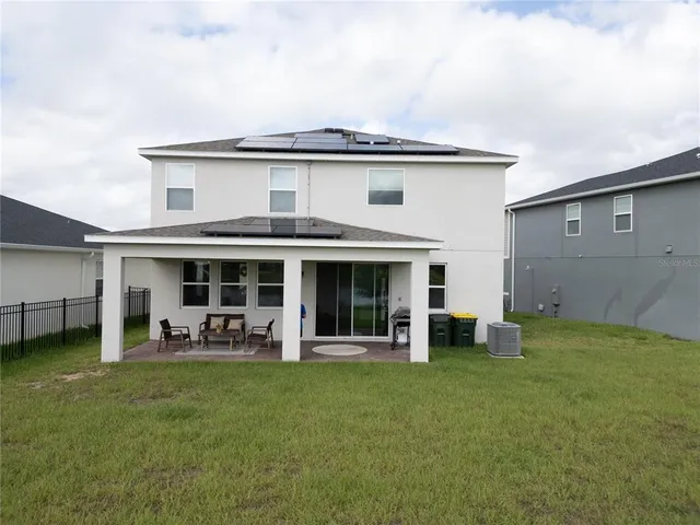 a view of a house with a yard and sitting area