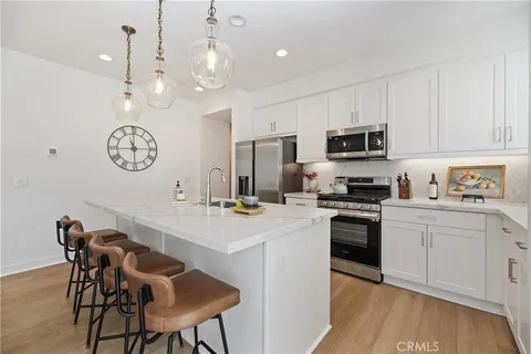 a kitchen with a dining table chairs refrigerator and cabinets