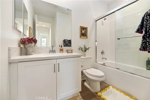 a bathroom with a sink toilet vanity and shower
