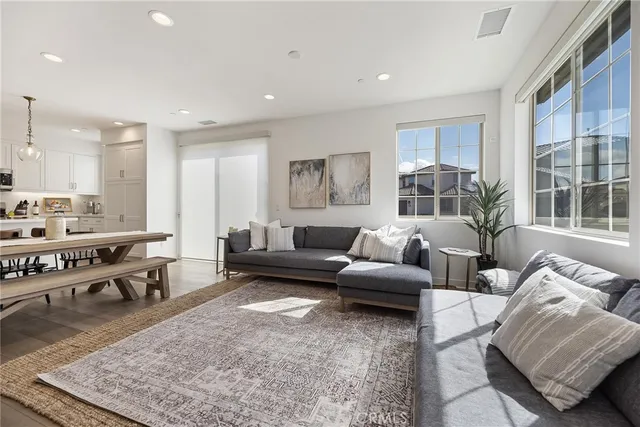 a living room with furniture wooden floor and a large window