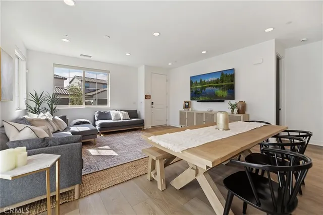 a living room with furniture a flat screen tv and a large window