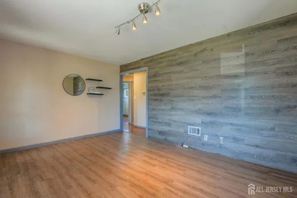 a view of an empty room with wooden floor