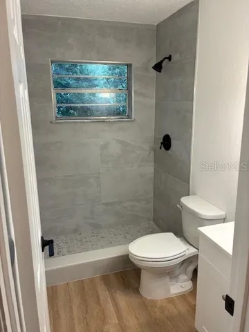 a white toilet sitting next to a bath tub