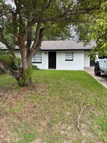 a front view of a house with yard and trees