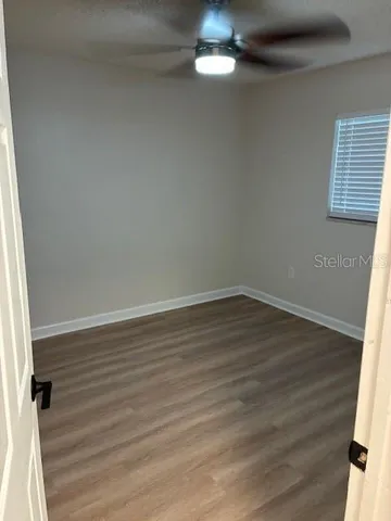 a view of a small space with wooden floor and a window