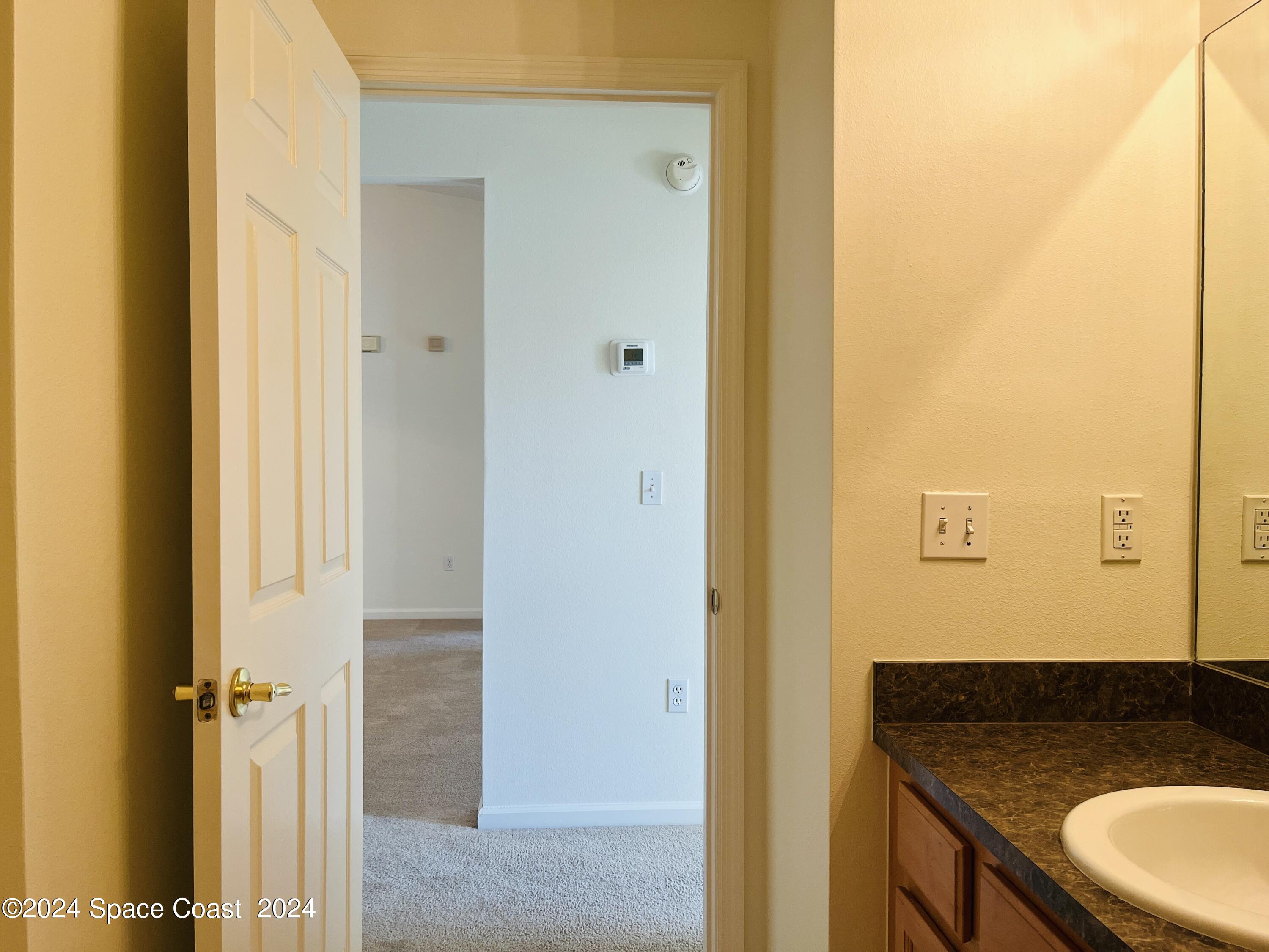 4006 Meander Place, Unit 201 Rockledge, FL 32955 - Photo 11 of 20 a bathroom with a granite countertop sink and a mirror