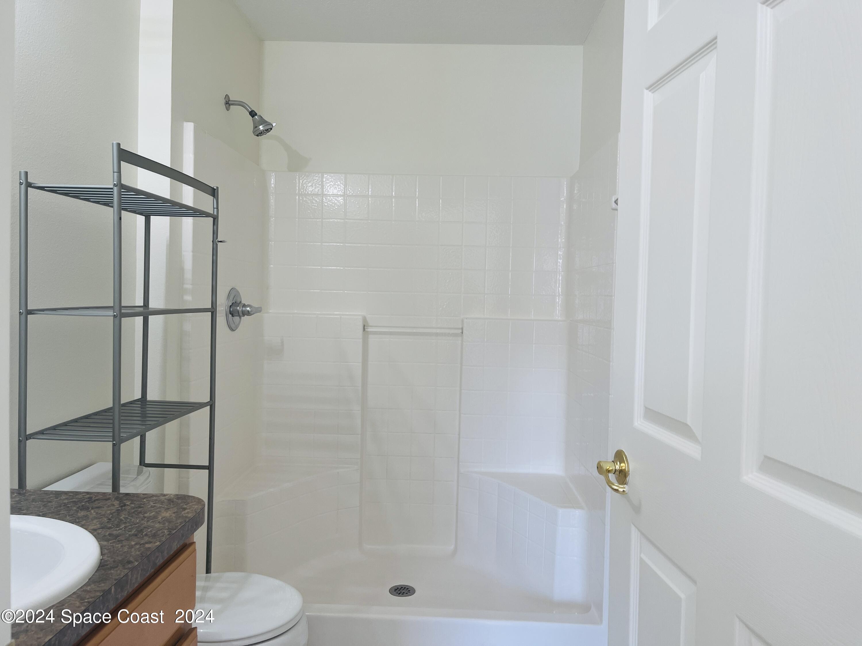 4006 Meander Place, Unit 201 Rockledge, FL 32955 - Photo 8 of 20 a bathroom with a toilet and a shower