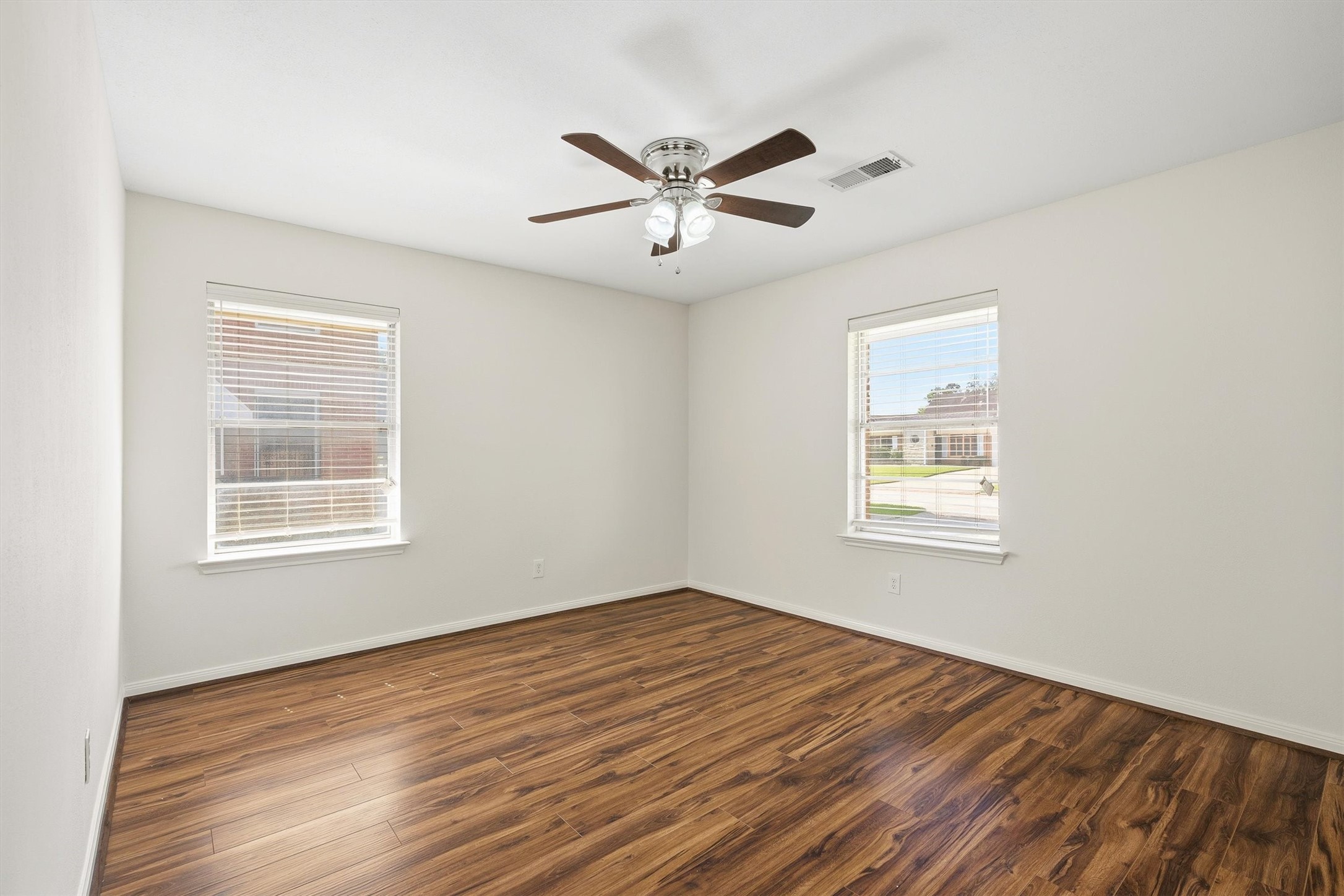 3331 Arbor Street Houston, TX 77004 - Photo 17 of 30 The guest room is bright and airy, featuring hardwood floors, two windows for natural light, and a ceiling fan. Its neutral walls offer a blank canvas for personalization.
