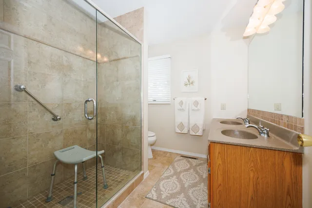 a bathroom with a granite countertop sink a toilet and shower