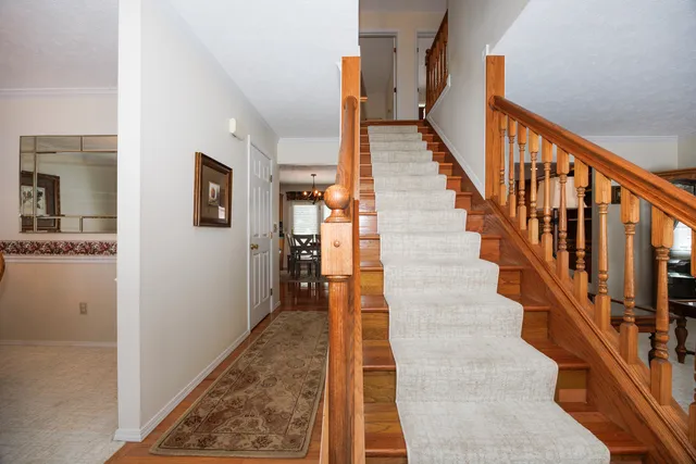 a view of staircase with wooden floor and a rug
