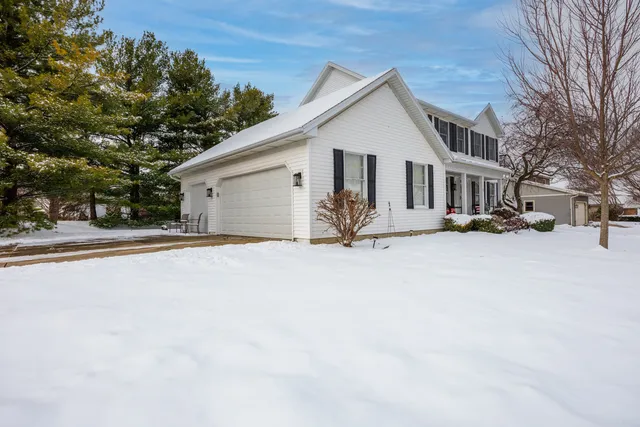 a view of a white house with a yard covered in snow