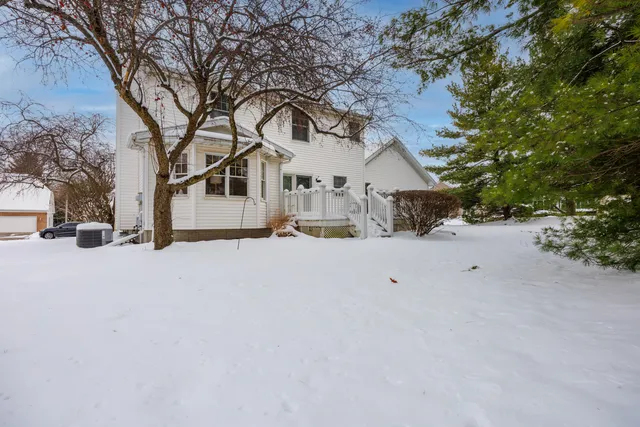 a view of house with a snow in front of yard