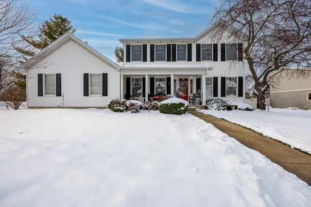 a front view of a house with a yard covered in snow