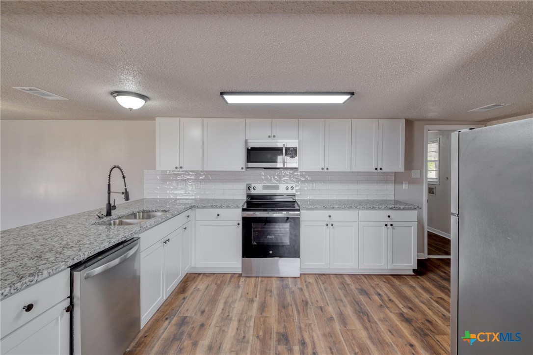 4978 Sparta Road Belton, TX 76513 - Photo 11 of 32 a kitchen with a sink stove and cabinets