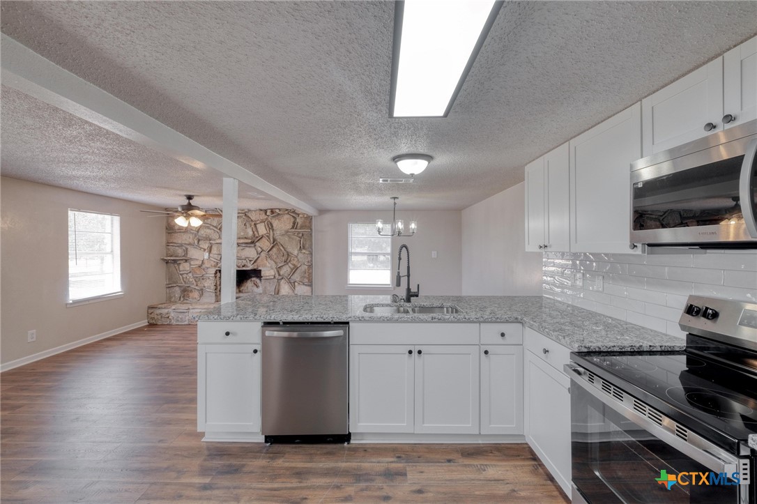 4978 Sparta Road Belton, TX 76513 - Photo 12 of 32 a kitchen with stainless steel appliances granite countertop a sink stove and wooden floor