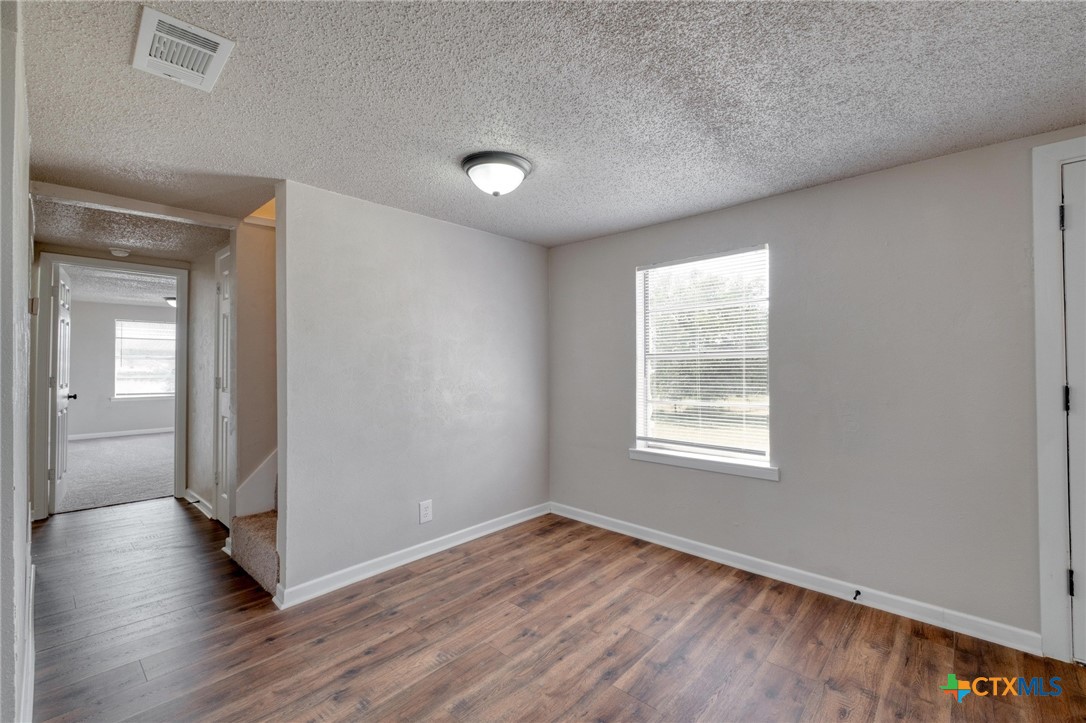 4978 Sparta Road Belton, TX 76513 - Photo 13 of 32 a view of an empty room with wooden floor and a window