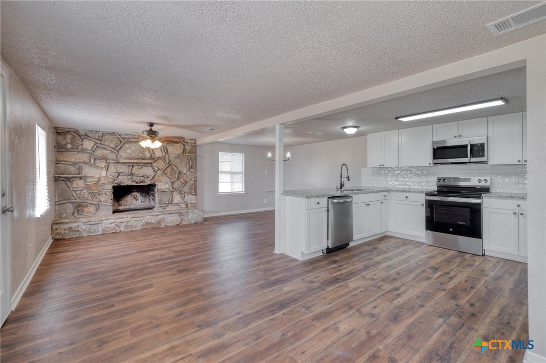 4978 Sparta Road Belton, TX 76513 - Photo 14 of 32 a large kitchen with cabinets wooden floor and stainless steel appliances
