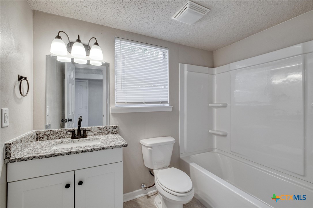 4978 Sparta Road Belton, TX 76513 - Photo 17 of 32 a bathroom with a granite countertop sink toilet and shower