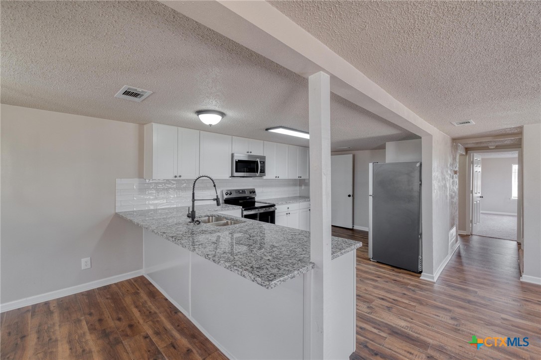 4978 Sparta Road Belton, TX 76513 - Photo 10 of 32 a kitchen with stainless steel appliances granite countertop a sink refrigerator and cabinets