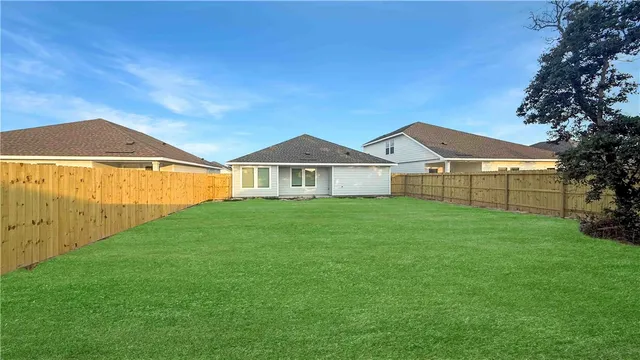 a view of a yard in front of a house with large tree