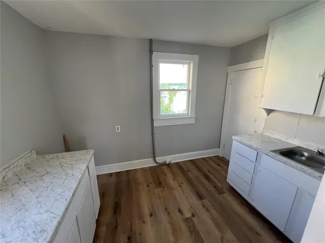 a room with wooden floor and white walls