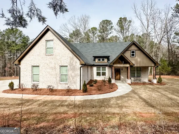 a front view of a house with a yard outdoor seating and garage