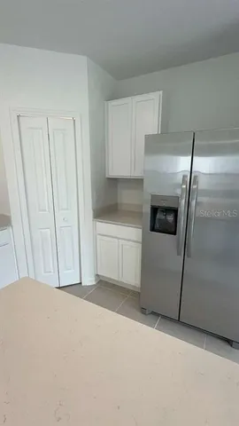 a kitchen with a refrigerator sink and cabinets