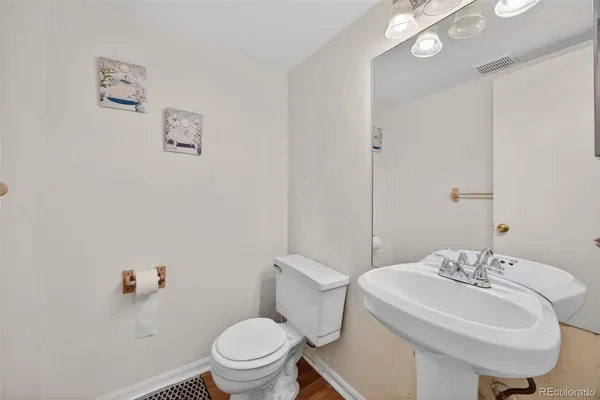 a bathroom with a sink a toilet and a mirror