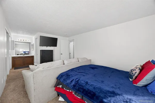 a living room with a bed and a television