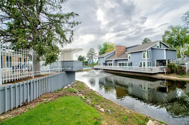 a view of a house with wooden deck and a small yard