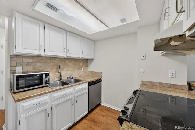 a kitchen with stainless steel appliances granite countertop a sink stove and cabinets