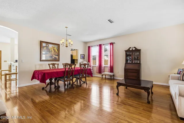 a view of a living room filled with furniture and wooden floor