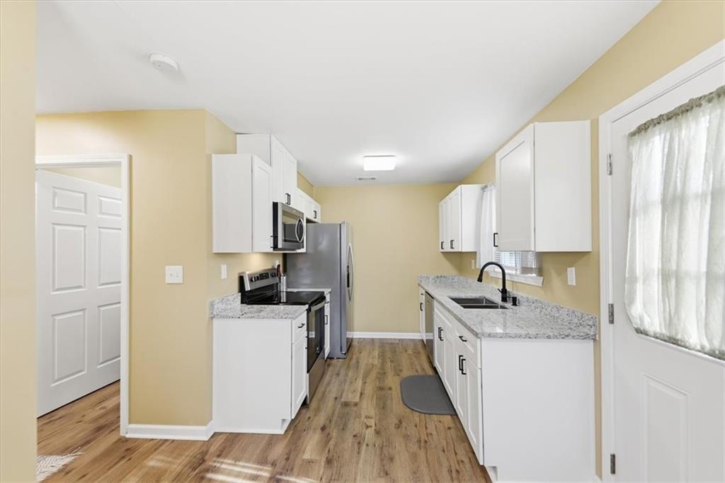 1318 Reece Road Woodstock, GA 30188 - Photo 12 of 40 a kitchen with a sink a stove top oven and refrigerator