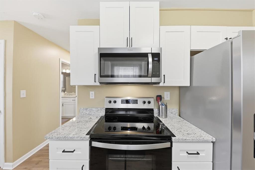 1318 Reece Road Woodstock, GA 30188 - Photo 14 of 40 a kitchen with granite countertop a stove and a microwave