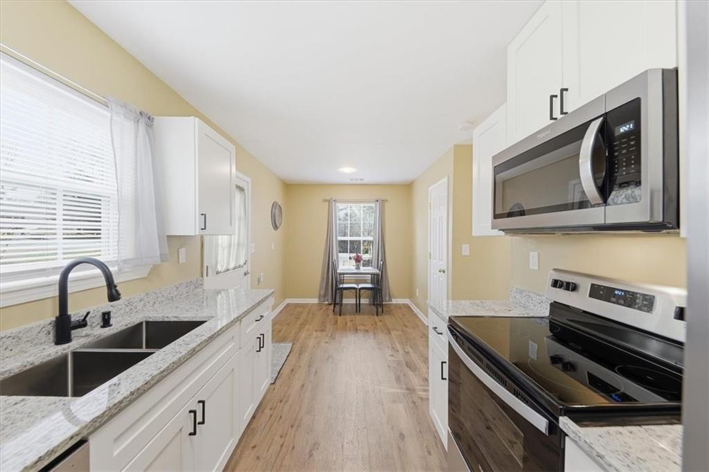 1318 Reece Road Woodstock, GA 30188 - Photo 16 of 40 a kitchen with granite countertop a stove and a sink