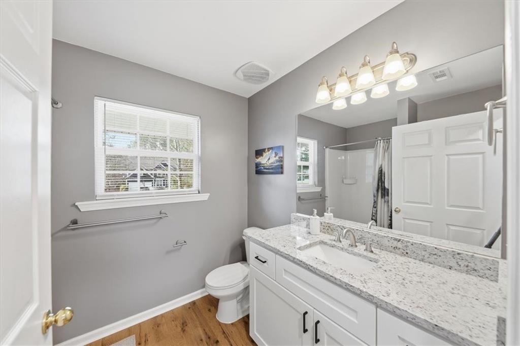 1318 Reece Road Woodstock, GA 30188 - Photo 18 of 40 a bathroom with a granite countertop sink a toilet and a mirror