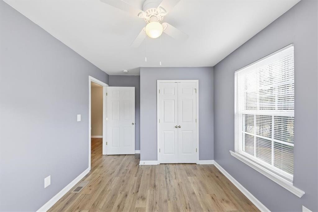 1318 Reece Road Woodstock, GA 30188 - Photo 22 of 40 a view of an empty room with wooden floor and a window