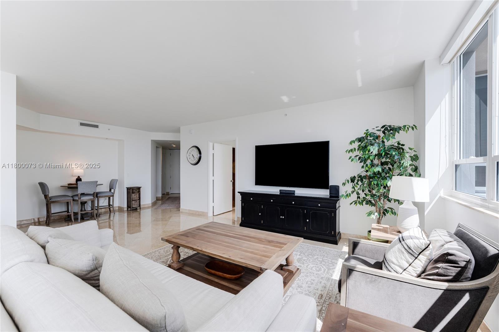 801 Brickell Key Boulevard, Unit 1911 Miami, FL 33131 - Photo 6 of 21 a living room with furniture a flat screen tv and a large window