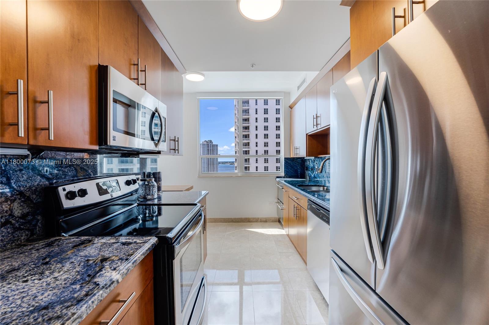 801 Brickell Key Boulevard, Unit 1911 Miami, FL 33131 - Photo 7 of 21 a kitchen with stainless steel appliances granite countertop a refrigerator a stove and a sink with wooden floor