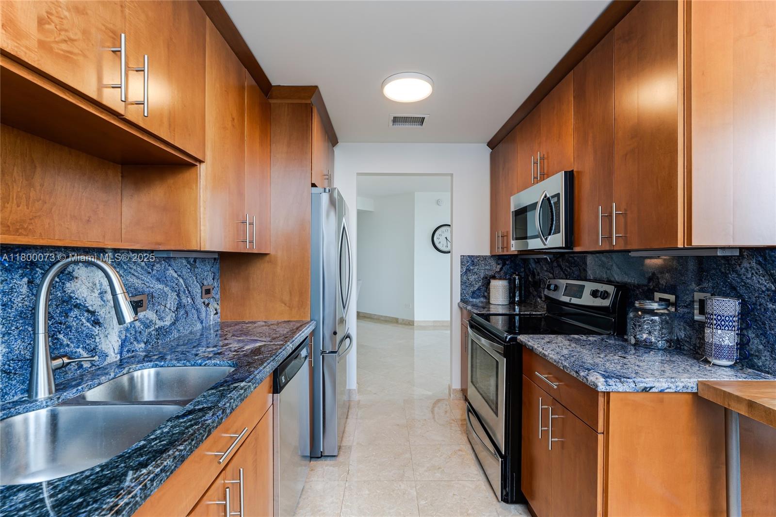 801 Brickell Key Boulevard, Unit 1911 Miami, FL 33131 - Photo 8 of 21 a kitchen with stainless steel appliances granite countertop a sink a stove and a refrigerator