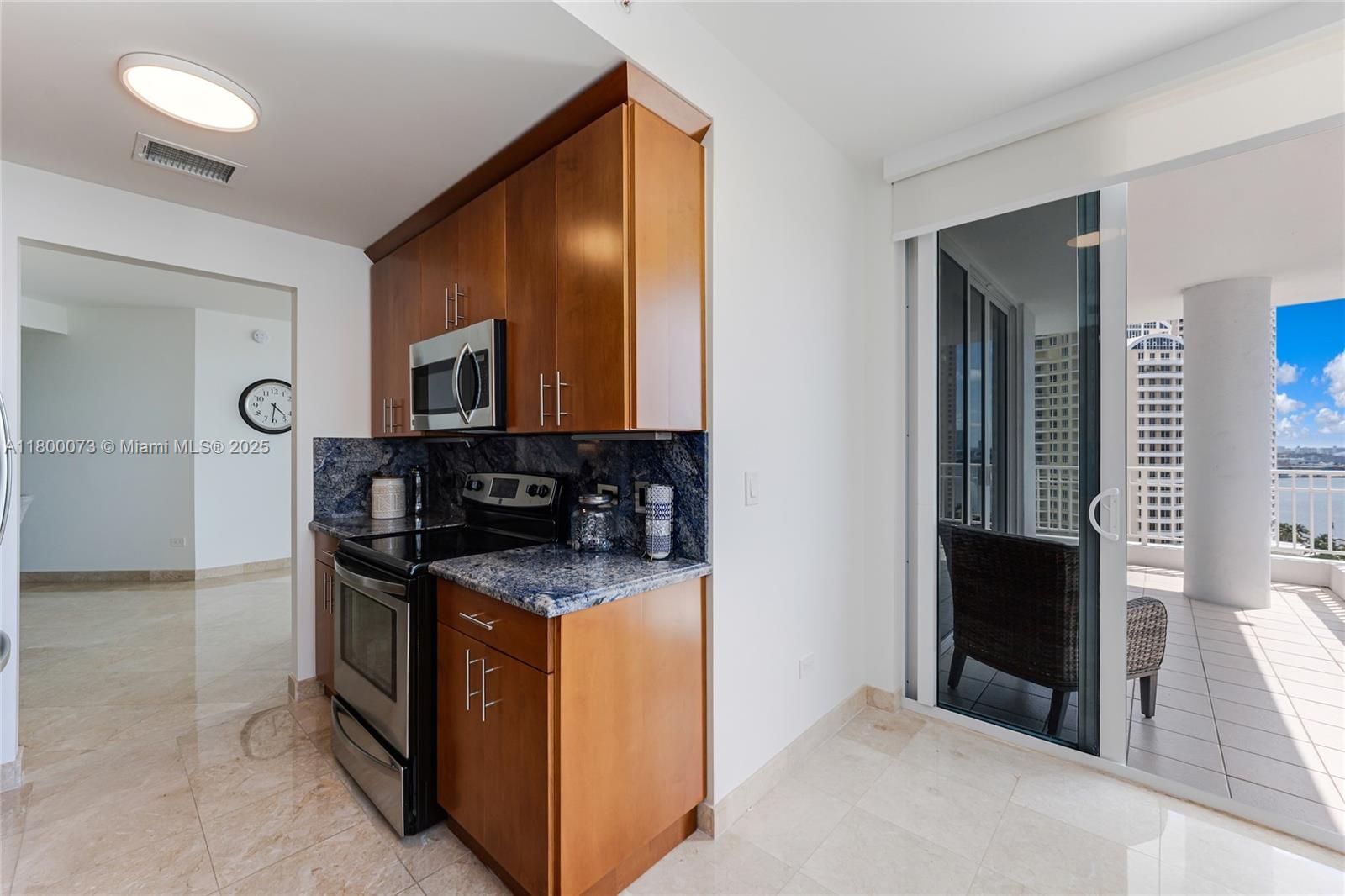 801 Brickell Key Boulevard, Unit 1911 Miami, FL 33131 - Photo 9 of 21 a kitchen with stainless steel appliances granite countertop a stove and a microwave