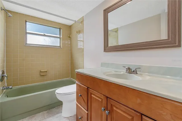 a bathroom with a granite countertop toilet sink and mirror