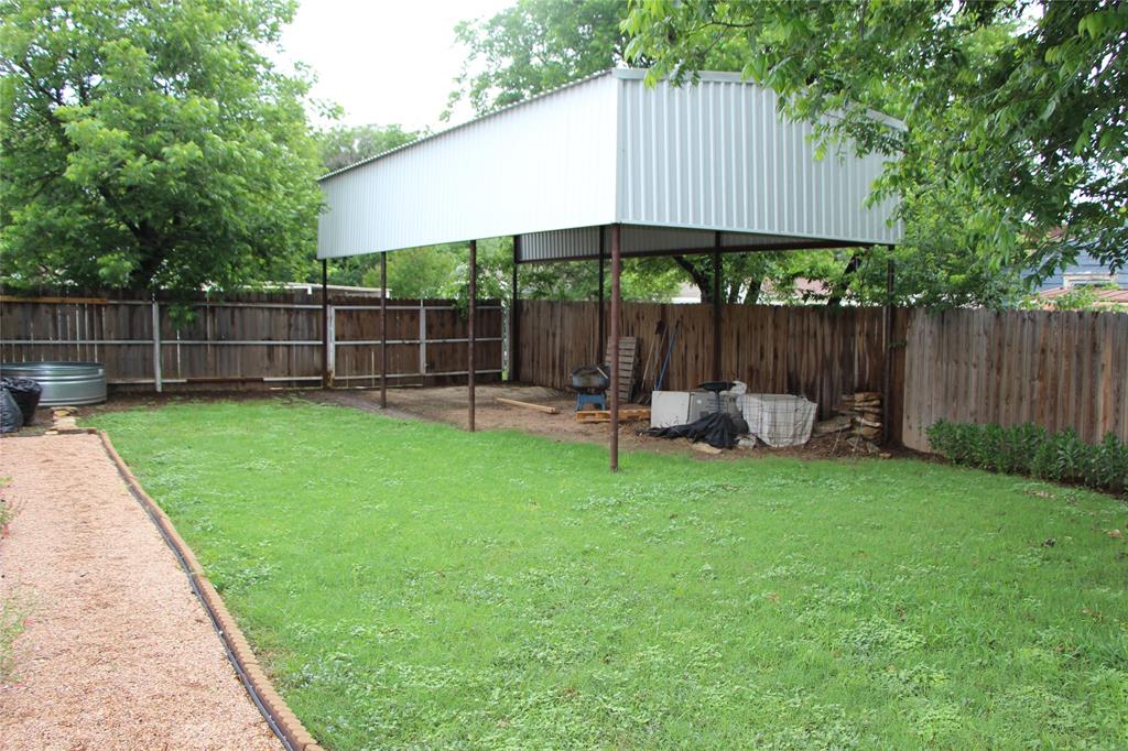 800 Griffin Road Albany, TX 76430 - Photo 15 of 15 a view of a backyard with a small cabin and a chair