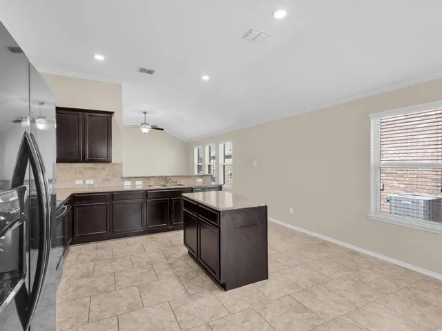 a kitchen with stainless steel appliances granite countertop a stove a sink and a refrigerator